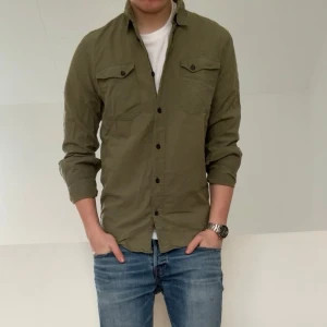 Nudie jeans overshirt - Säljer en sjukt nice overshirt perfekt nu till våren i färgen olivgrön! Overshirten är i bra skick utan nåra defekter och sitter i strl S! Hör gärna av er vid frågor elr funderingar!!