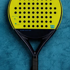 Wilson Juice Team padelracket - Oanvänd Padelracket från Wilson, modell Juice Team, i gul och svart färg. Racketen har rund form med många små hål och svart handtag med greppvänlig yta. Perfekt för dig som gillar padel och vill ha ett snyggt och sportigt racket.