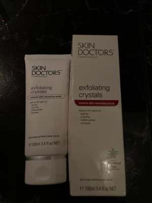 Skin Doctors exfoliating crystals scrub - Exfolierande scrub från Skin Doctors i vit tub, 100 ml. Produkten innehåller exfolierande kristaller och är framtagen för att minska ålderstecken, ärr, synliga porer och rynkor. Passar för dig som vill ha en intensiv hudförnyande behandling.