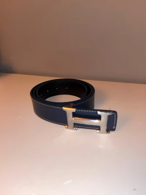 snyggt blått bälte med h-spänne. - Väldigt snyggt bälte med h-spänne. Pris kan självklart diskuteras vid snabb affär!