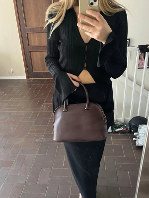 Vinröd väska Zara - En vinröd liten väska från Zara. Guldfärgad dragkedja