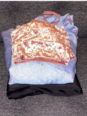 3 toppar  - Klädpaket med 3 toppar. Den blå är uppsydd så den slutar ungefär vid höfterna. Ingen lapp men skulle säga att den passar s-l då den knyts omlott resten är i storlek M. Svarta blusen har tappat en knapp följer med nya. Skriv för fler bilder 