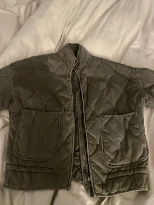 Quiltad jacka - Vattenläckan på bakre arm, se bild 3