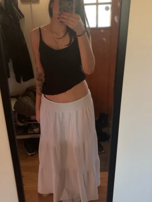 Vit Långkjol Med Volanger - Säljer en vit långkjol, passar perfekt till sommaren då den fläktar mycket !! Använd då och då under förra sommaren, har en liten fläck längre ner (be om bild) men den skulle kunna gå bort i tvätten💕