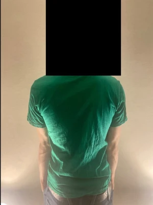 Grön t-shirt från Tommy Hilfiger - Snygg grön t-shirt från Tommy Hilfiger med diskret logga på bröstet. Klassisk rund halsringning och korta ärmar. Tillverkad i mjuk bomull som känns skön mot huden. Perfekt till jeans eller shorts för en enkel och stilren look.