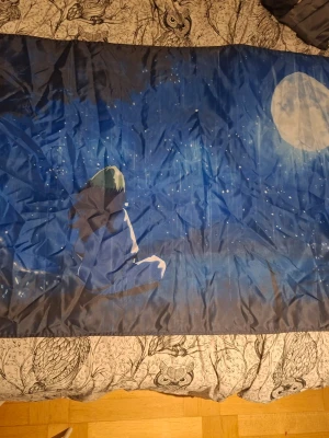 Billie eilish flagga my future - Unikt blått påslakan med tryck av en person som sitter och tittar på en stor måne under en stjärnklar natthimmel. Motiv i tecknad stil med djupa blå toner och vita detaljer. Perfekt för dig som gillar drömmiga och konstnärliga sängkläder.