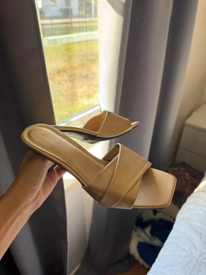 Guldiga klackar - Stilrena guldiga sandaler med fyrkantig tå och låg klack. De har breda korsade remmar i syntetmaterial och en öppen design som ger en trendig look. Perfekta för att lyfta din outfit med en enkel men chic touch. Storlek 39 men passa mig som bruka ha 38 i vanligt fall. 