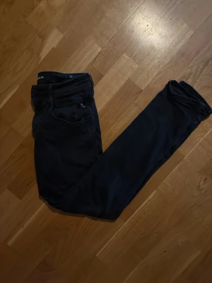Svarta skinny jeans från replay - Storlek 30/30. Säljer ett par svarta skinny jeans från Replay. Jeansen har klassisk femficksmodell, låg midja och smal passform. Materialet är stretchigt för extra komfort och de har diskreta detaljer vid fickorna. Perfekta för en trendig och avslappnad stil. Inköpta för 1600kr.  