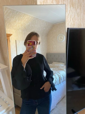 Volangblus - Plisserad svart blus med volangärmar, använd enstaka gånger. Storlek 36, men passar även 38