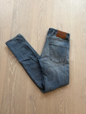 Ljusblå slitna Replay jeans - W28 - Replay jeans 👖✨ Blåa med riktigt snygga slitningar 💙🔥 (design från fabrik) Slim fit 👀 Nypris ca 1 500 kr 💸 – vårt pris 499 kr 🔥 Sitter riktigt bra och ger en clean men edgy look 😎 Passar på våran modell som är ca 175 cm och väger runt 62 kg(bild med jeansen på går att lösa), storlek W28 📏Kika gärna in vår profil för fler feta Replay-jeans i olika färger och storlekar 👀🔥 Hör av er om ni har frågor eller vill ha fler bilder 💬