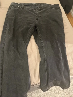 Svarta raka jeans - Säljer ett par svarta jeans med rak passform och klassisk femficksdesign. Jeansen har normal midja och är tillverkade i denim. Perfekta för en avslappnad och stilren look.