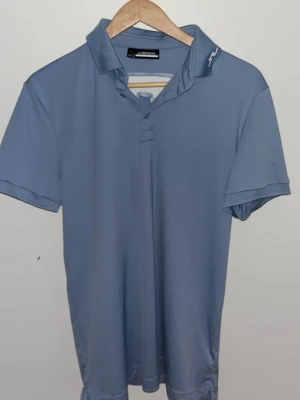 J.lindeberg piké - En väldigt snygg piké från J.Lindeberg. Ljus blå med vit textur på krage och rygg, helt ny och inte använd. Sportigt material till tex golf eller bara ha vardags. Pris kan diskuteras 