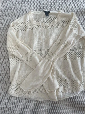 Vit stickad tröja från Lindex - Snygg vit stickad tröja från Lindex med genombrutet mönster och rund halsringning. Tröjan har långa ärmar och en luftig, avslappnad passform som passar perfekt till jeans eller kjol. Materialet är mjukt och bekvämt.