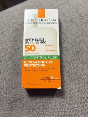 La Roche-Posay Anthelios UVmune 400 SPF50+ - Oljekontrollerande solskyddsfluid med SPF50+ från La Roche-Posay. Ger ultralång UVA-skydd, mattande effekt upp till 12 timmar och passar känslig hud. Kommer i en vit och orange förpackning, 50 ml.