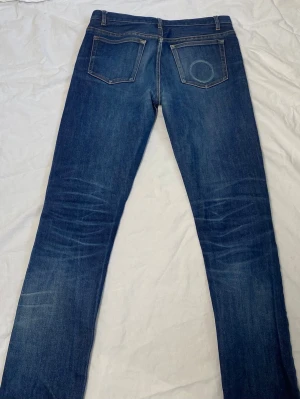 Blå raka jeans från A.P.C. - Säljer ett par klassiska blå jeans från A.P.C. i rak modell. Jeansen har fem fickor, snygga slitningar och kontrastsömmar. Tillverkade i kraftig denim som ger en tidlös look. Perfekta för dig som gillar stilrena och enkla jeans. Jeansen har även en Snusfade på baksidan som ger en snygg detalj! Jeansen är i storlek L30 W30 och tveka inte på att höra av er om ni har några frågor!