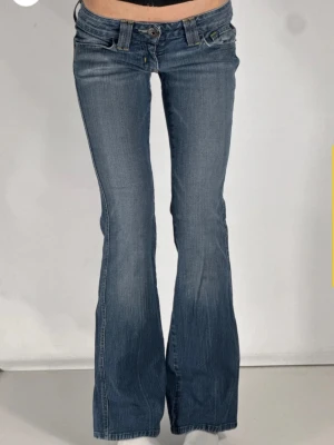 Lågmidjade bootcut jeans - Ett par blåa bootcut jeans från guess som är köpta på tinlesell. Dom är aldrig använda av mig och säljer då dom tyvärr var lite för korta. Midjemått rakt över: 35 cm Innerbenslängd: 80 cm Grenhöjd: 15 cm 🩷