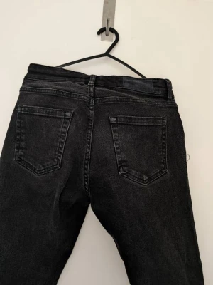 Svarta raka jeans från KARVE - Säljer ett par svarta jeans från KARVE med klassisk femficksmodell och raka ben. Jeansen har en snygg tvättad finish och silverfärgade nitar. Perfekta för en avslappnad och trendig look.