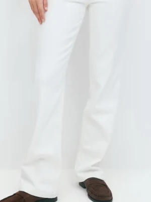 Vita bootcut jeans med utsvängda ben - Snygga vita bootcut jeans med utsvängda ben och klassisk femficksdesign. Jeansen har låg midja och är tillverkade i ett stretchigt denimtyg som ger en bekväm passform. Perfekta för dig som vill ha en stilren och trendig look. Har använts en gång❤️ Skriv gärna.