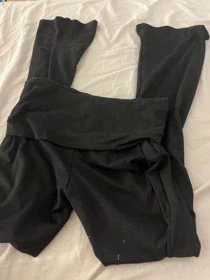 Svarta yoga pants  - Säljer ett par svarta leggings med bred linning . De är stretchiga och sitter tight, perfekta till oversized tröjor eller hoodies. Materialet känns mjukt och följsamt, troligen i bomulls- eller polyesterblandning.