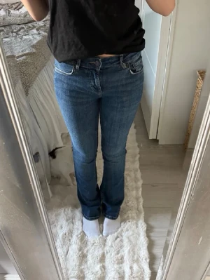 Blå bootcut low waist jeans  - Snygga blå bootcut jeans low waist. Jeansen har en lätt utsvängd benform och är tillverkade i denim med en liten stretch för extra komfort. Perfekta för en avslappnad och trendig look.