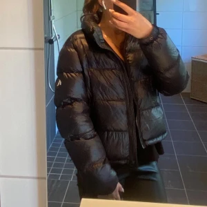 Svart glansig pufferjacka  - Svart glansig puffjacka från Superdry, mycket fint skick. Passar även mindre kille. 