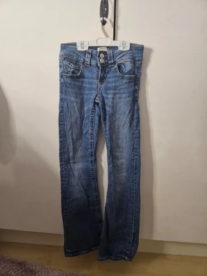 Blå bootcut jeans från Gina Tricot - Jag säljer ett par blå bootcut jeans från gina tricot i storlek 152. OBS VITKIGT. de är använda några gånger, och har även ett slitage vid blixtlåset (se de två sista bilderna), som jag har sytt så gott som jag kan. Jag säljer därför de för ett väldigt billigt pris. 💓