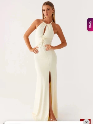 Gul balklänning Peppermayo - Fin ljusgul klänning med halterneck, knyt i nacken och öppen rygg. Klänningen har en snygg twistdetalj framtill, slits framtill och figurnära passform. Perfekt till bal eller finare evenemang. Aldrig använd med lappen kvar. 