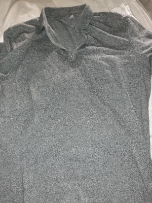 Gråmelerad halvzip tröja - Snygg gråmelerad tröja med halv dragkedja och krage. Perfekt för lager-på-lager och chill vardagsstil. Mjuk och bekväm,