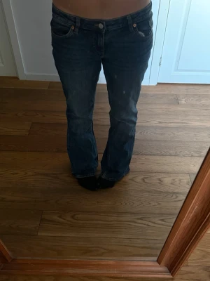 Mörkblå Jeans - Jättesnygga lågmidjade bootcut jeans från Monki!! Nästan inte använda och ser ut som nya. De har en väldigt fin brodering på bakfickorna💓