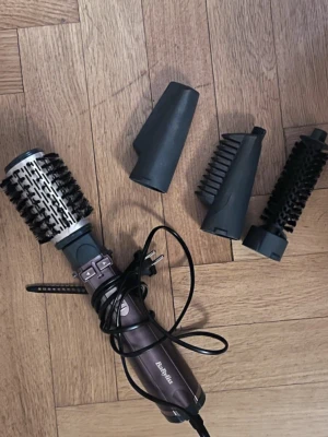 BaByliss varmluftsborste med tillbehör - Multifunktionell varmluftsborste från BaByliss med fyra utbytbara munstycken. Perfekt för att styla och forma håret till blow out look.