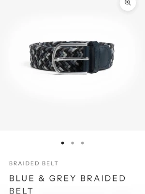 Blått och grått flätat bälte OneWear - Snyggt flätat bälte från OneWear i blå och grå färgskala. Bältet har en silverfärgad metallspänne och detaljer i mörkt skinn. Perfekt accessoar för att lyfta din outfit med en modern touch.
