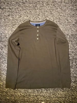 Mörkgrön henley / farfarströja - En riktigt snygg mörkgrön henley/farfarströja med vita knappar som är oanvänd. Storlek L. 100% bomull. Skriv gärna om du har några frågor! Pris kan diskuteras :)