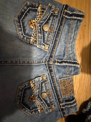 Lågmidjade jeansshorts – Karma Blue – med tryck - Lågmidjade jeansshorts – Karma Blue – med tryck  Snygga lågmidjade jeansshorts från Karma Blue med coola och unika tryck som verkligen sticker ut. Trendig modell som sitter fint på kroppen och passar perfekt till sommar och streetwear-outfits. Lätta att matcha med olika toppar.  Jag säljer dem eftersom de tyvärr inte kommer till användning.  Märke: Karma Blue Storlek: 12 (motsvarar ca XS/S i Sverige, ungefär EU 34–36) Skick: Väldigt bra skick Pris: 350 kr  Hör gärna av dig vid frågor eller intre