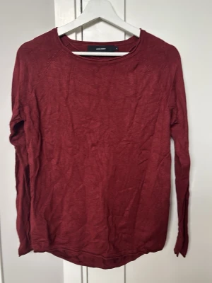Mörkröd långärmad tröja - En enkel och snygg mörkröd långärmad tröja. Tröjan har rund halsringning och är gjord i ett mjukt, tunt material som känns skönt mot huden. Perfekt att matcha med jeans eller kjol för en avslappnad look.