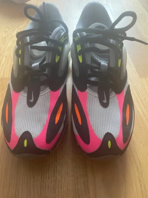 Nike Air Max 720 neon och svart - Nike Air Max 720 sneakers med futuristisk design i grått, svart, neonrosa och inslag av orange och gult. Ovandel i mesh och syntet, stora luftbubblor i sulan och svarta skosnören. Perfekta för dig som vill sticka ut med färg och stil.