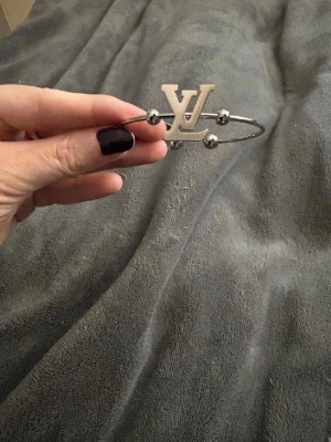 Silvrigt armband  - Silvrigt armband. Delvis ställbart, då kan man trycka in det lite och även böja ut det lite. Aldrig använt.