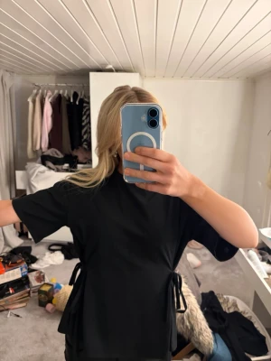 Svart topp med knyt från Nelly - Säljer en svart topp från Nelly som aldrig är andvänd