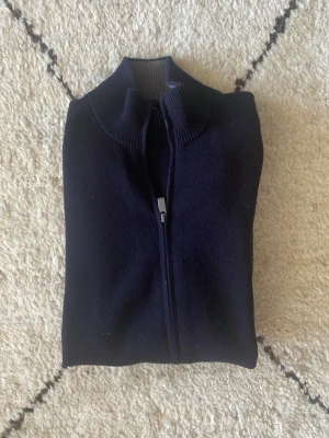 Mörkblå ziptröja med hög krage - Riktigt najs stickad zip tröja från Massimo Dutti! Bra skick inte använd särskilt mycket. Nypris runt 1300kr, köp för endast 400kr. Storlek M! 