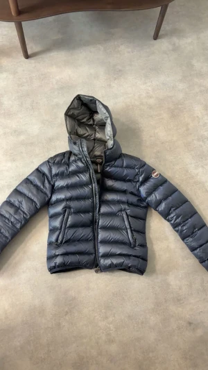 Mörkblå dunjacka från Colmar - Säljer en snygg mörkblå dunjacka från Colmar Originals. Dragkedjan är lite trög men funkar som den ska att stänga o öppna