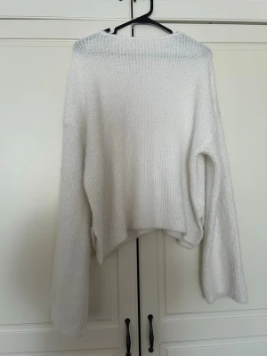 Vit fluffig stickad tröja - Mysig vit stickad tröja med oversized passform och långa, vida ärmar. Tröjan har en fluffig textur och är perfekt för lager-på-lager. Enkel och stilren design som passar till många outfits.. pris kan diskuteras 🌸storlek M-L