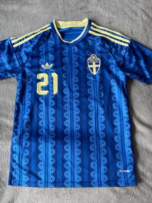 Sverige Kulusevski 21  - Riktigt fet Sverige-tröja med sjukt clean detaljer och Kulusevski tryck på ryggen 👌 Blå/guld färgerna och mönstret gör att den sticker ut galet mycket.  • Sverige landslag • Kulusevski #21 • storlek M (L passar M) • Climacool • Premiumdetaljer & snygg passform • Perfekt till både match, outfit eller samling  En av de snyggaste Sverige-tröjorna enligt mig 🇸🇪  💰 Pris: 449kr 📍  skickas  