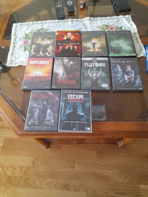 Samling med 10 DVD-filmer - En samling med 10 olika DVD-filmer i plastfodral. Omslagen är färgstarka och filmerna täcker genrer som action, thriller och skräck. Perfekt för dig som gillar att samla på film eller vill ha ett varierat utbud till hemmabion.