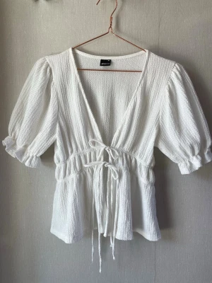 Vit blus med knyte framtill - Superfin vit blus från Gina Tricot med djup v-ringning, puffärmar och knyt i midjan 💕