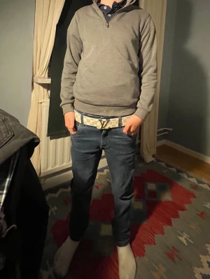 Grå halvzip tröja - Snygg grå tröja med halv dragkedja och hög krage. Tröjan har en enkel och stilren design med ribbade muddar vid ärmslut och nederkant. Perfekt för lager-på-lager och passar till det mesta från Jack Jones 