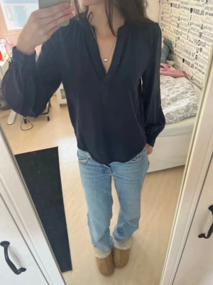 Mörkblå blus från Kappahl - Snygg mörkblå blus från Kappahl med v-ringad hals och avslappnad passform. Perfekt att styla med jeans eller kjol.