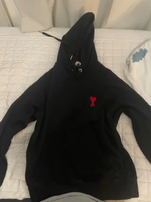 Svart hoodie från Ami Paris med rött hjärta. Size S - Svart hoodie från Ami Paris med en rött hjärta helt svart på baksidan. Size S