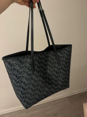 Shoppingväska Coach - Stilren äkta Coach shoppingväska i mörkblå med  monogram. Väskan har långa svarta handtag och är tillverkad i tåligt material med kontrastsömmar. Köpt i Paris 🩷 lite slitna band men annars gott skick. Originalpris ca 600€.