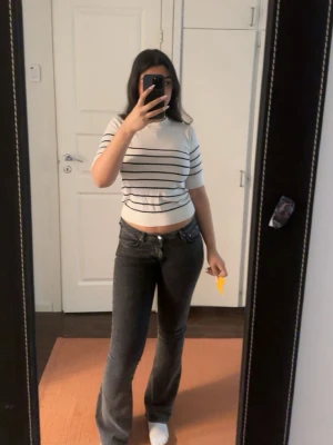 Mörkgråa bootcut jeans med låg midja - Jeansen är använda ett par gånger men i gott skick. Jag är 167 lång och byx längden är jätte bra. 