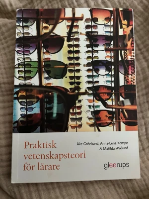 Praktisk vetenskapsteori för lärare - Boken 'Praktisk vetenskapsteori för lärare' av Åke Grönlund, Anna-Lena Kempe och Matilda Wiklund ger en introduktion till vetenskapsteori och forskning för lärare. Omslaget har ett färgstarkt motiv med solglasögon och boken är tryckt i mjukt omslag.