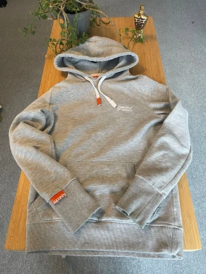 Grå Superdry hoodie - Säljer min väldigt snygga superdry hoodie. Passar S/XS sitter lite mer slim. Skriv vid frågor!🥂